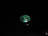 a close up of a green and black diamond on a black surface
