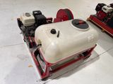 a white tank sitting on a red cart in a warehouse