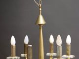 a close up of a chandelier with five candles on it