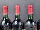 three bottles of wine with a creepy face on the label