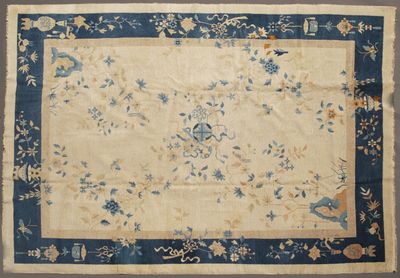 un tapis chinois ancien avec une bordure bleue et un motif floral
