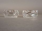 pair of clear glass ashtrays on a white surface