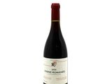 a bottle of red wine sitting on top of a white table