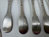six silver spoons are lined up in a row on a table
