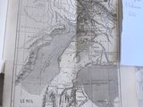 une vieille carte posée sur une table, recouverte d'un bout de papier