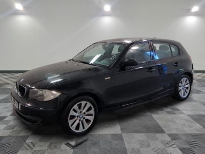 la photo d'une voiture noire garée sur un sol en damier