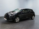 La Toyota Corolla noire est garée dans une grande pièce.