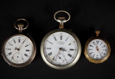 Trois types différents de montres de poche sont exposés sur un fond noir