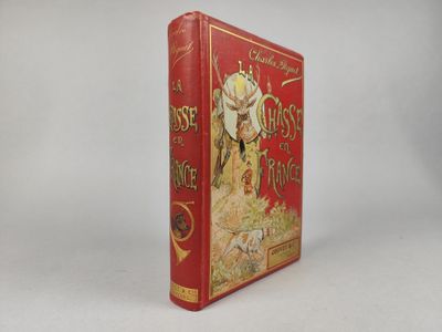un vieux livre rouge posé sur une table à côté d'un mur blanc
