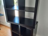 une bibliothèque noire sur laquelle sont posés plusieurs livres