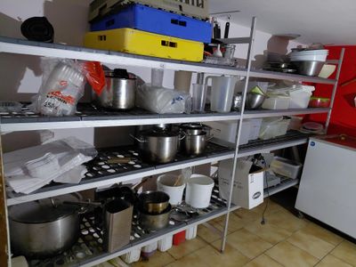 many pots and pans on the shelves in the kitchen