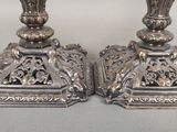 une paire de bougeoirs anciens en argent, ornés de motifs élaborés