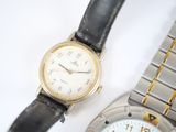 two watches sitting next to each other on a white surface