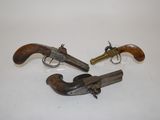 two old revolvers sitting on a white surface with one being used as a gun