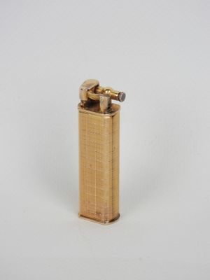 un briquet doré posé sur une surface blanche