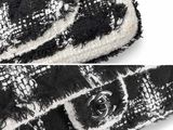 a close up of a black and white bag with a button
