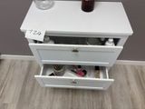 a white chest of drawers with a vase on top of it