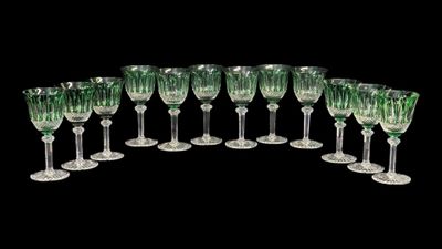 six verres à vin verts sont alignés sur une surface noire