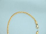 a close up of a gold necklace on a blue surface