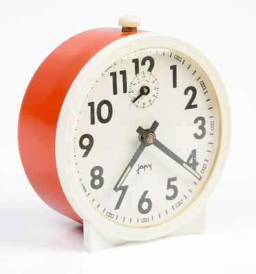 a red and white alarm clock on a white background