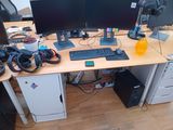 a desk with two monitors and a keyboard on it