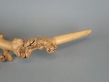 a picture of a wooden pipe with a carved animal on it