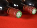 several bottles of wine are lined up on a red cloth