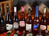 many bottles of wine sitting on a table next to each other