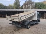 a white truck with a flat bed parked in a dirt lot