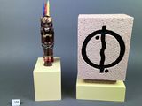 a small statue of a man standing next to a small statue of a man
