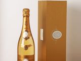 des bouteilles de champagne posées sur une table en bois, à côté d'une boîte marron
