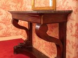 a mirror and a table in a room with a red carpet