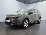La Citroën grise est garée dans une grande pièce