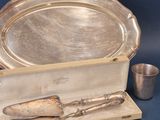 a silver tray with a knife, spoon and cup on it