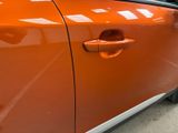 an orange car that is parked in a parking lot