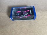 a pink toy car in a box on the floor