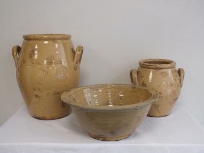 trois vases posés sur une table blanche recouverte d'une nappe blanche