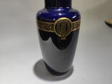 un vase bleu posé sur une table, avec un livre devant
