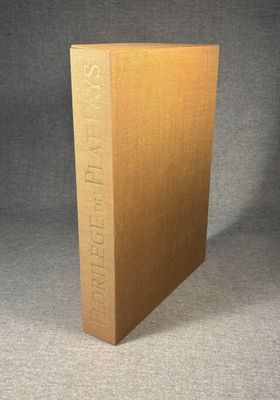 a brown book sitting on top of a table next to a gray wall