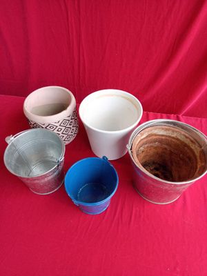 many cups and bowls sitting on a red cloth