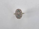 a close up of a silver ring with green and white stones