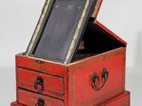 a small red box with a mirror on top of it