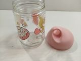 a glass jar with a pink lid next to a pink cup
