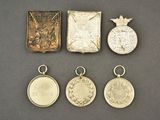 four silver medals and a book on a table