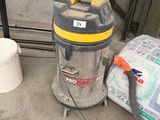 un aspirateur et un seau posés par terre près d'une fenêtre
