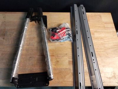 deux morceaux de métal posés sur une table en bois, à côté de deux agrafeuses