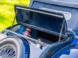 a blue car with a cooler in the back of it