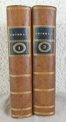 two old books sitting on top of a table next to each other