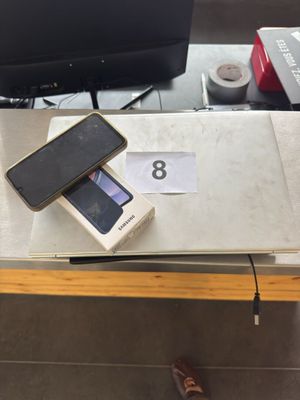 a cell phone sitting on top of a table next to a tv