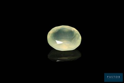 a close up of a yellow jade stone on a black surface